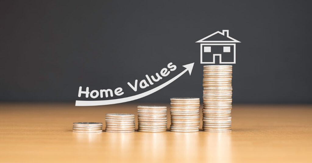 A stack of change that gradually increases to signify your home value climbing with a bathroom conversion project. A house sits on top of the highest stack of coins. 